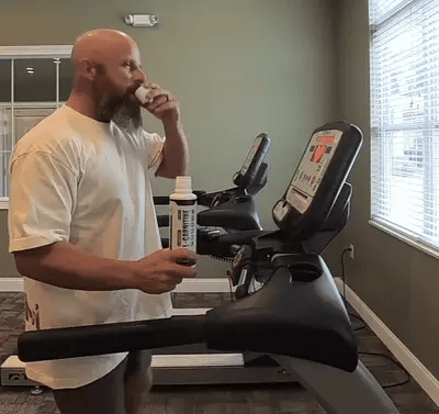 Mid aged guy drinking Lcarnitine from the bottle cap